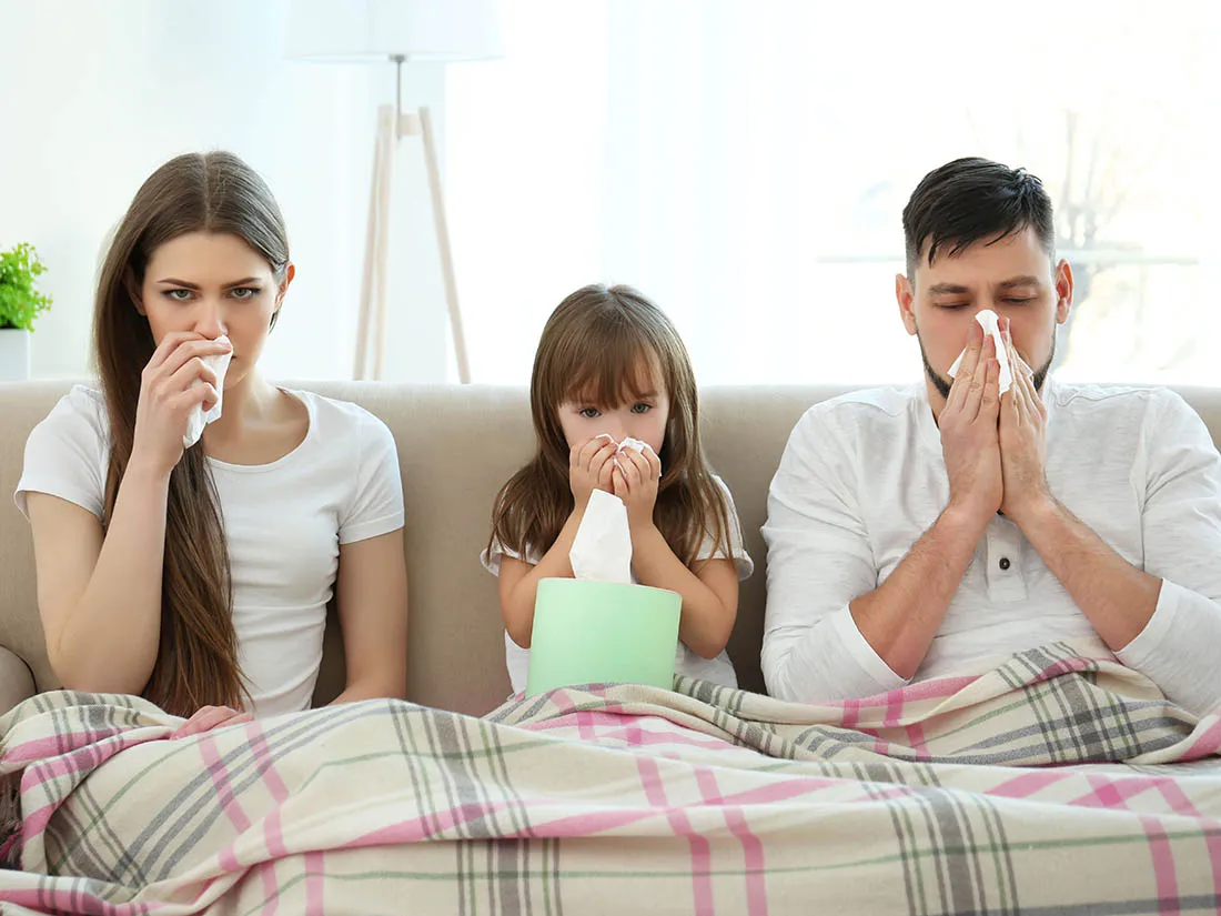 A sick family wipes their noses with tissues